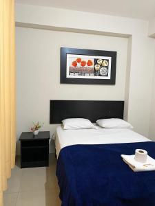 una camera d'albergo con un letto e una foto appesa alla parete di Hotel Sengor a Urbanizacion Buenos Aires