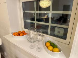 a counter with two bowls of fruit and wine glasses at Bagargården 8 in Åre