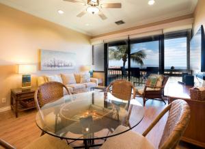 sala de estar con mesa de cristal y sillas en Maui Vista 3406 - Ocean View Penthouse Sleeps 7, en Kihei