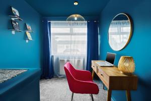 um quarto azul com uma secretária com uma cadeira vermelha e um espelho em Unique 2 Bedroom House - Free Wifi & Netflix - Garden - Parking - 4VC em Minworth