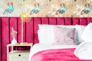 um quarto com uma parede rosa e papel de parede de pavão em Unique 2 Bedroom House - Free Wifi & Netflix - Garden - Parking - 4VC em Minworth