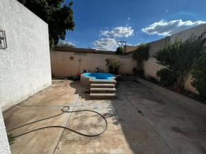 a patio with a swimming pool and a hose at Casa ROMA in Ciudad Obregón