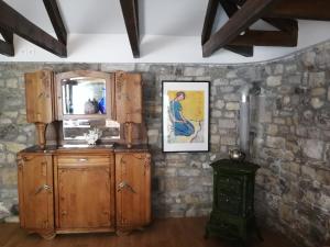 um quarto com um armário de madeira e um espelho em Cozy village house em Skamnéllion