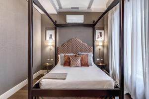 a bedroom with a canopy bed with pillows at Antica Residenza Del Corso in Rome