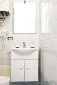 uma casa de banho branca com um lavatório e um espelho em Panoramic centre in Naples em Nápoles