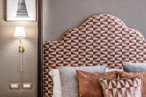 a bedroom with a bed with a headboard and pillows at Antica Residenza Del Corso in Rome