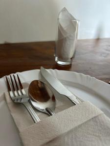 einen Teller mit Löffel und Gabel und ein Glas Milch in der Unterkunft Castelo fort in Caparaó Velho