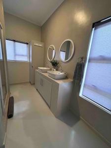 ein Badezimmer mit zwei Waschbecken und zwei Spiegeln in der Unterkunft Comfortable home centrally located in Hoedspruit in Hoedspruit