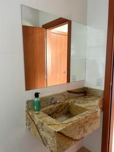 ein Badezimmer mit einem Waschbecken und einem großen Spiegel in der Unterkunft Castelo fort in Caparaó Velho + 24 Fotos