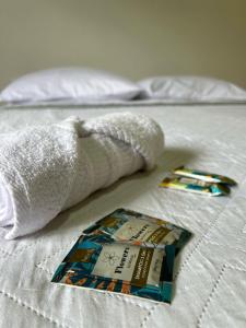 ein Handtuch und ein Buch auf einem Bett in der Unterkunft Castelo fort in Caparaó Velho