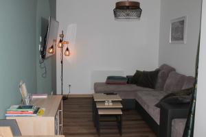 - un salon avec un canapé et une table basse dans l'établissement Appartement Royale, à Rocroi
