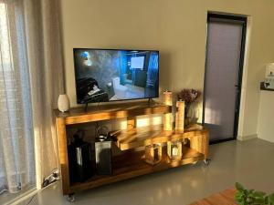 a flat screen tv sitting on top of a wooden entertainment center at Comfortable home centrally located in Hoedspruit in Hoedspruit