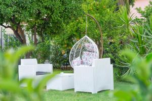 biała huśtawka na podwórku z roślinami w obiekcie Vincent B&B - vicini al mare w mieście Scalea