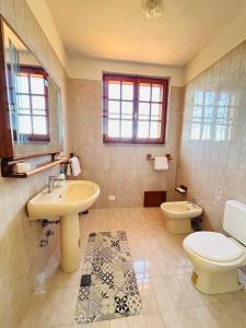 ein Bad mit einem Waschbecken und einem WC in der Unterkunft Villa Jolies in Viddalba