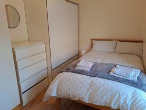 a small bedroom with a bed and a dresser at Drogheda Townhouse in Drogheda