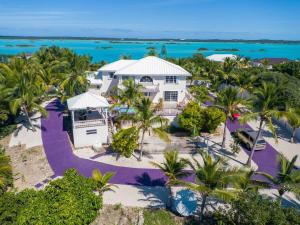 an aerial view of a house with palm trees and the ocean at NEW Chalk Sound Home BBQ Pool Beach Steps Away in Providenciales