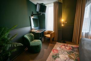 a living room with a chair and a tv on a wall at Stadshotel Heerlen in Heerlen