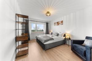 1 dormitorio con cama, escalera y sofá en VINFUL: Premium-Apartment mit Balkon und Parkplatz en Mülheim an der Ruhr