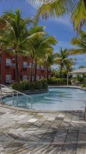 - une piscine bordée de palmiers en face d'un bâtiment dans l'établissement Lagoa Quente Hotel - Parque Aquático, à Caldas Novas