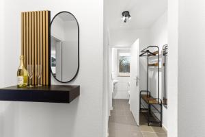 La salle de bains est pourvue d'un miroir, d'un lavabo et de toilettes. dans l'établissement VINFUL: Premium-Apartment mit Balkon und Parkplatz, à Mülheim 26 autres photos