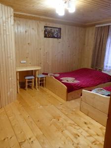 Schlafzimmer mit einem Bett, einem Schreibtisch und einem Tisch in der Unterkunft Смерека in Mykulytschyn