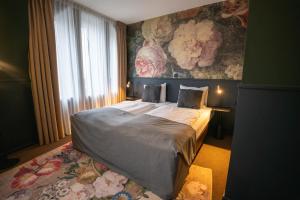 - une chambre avec un grand lit et un mur fleuri dans l'établissement Stadshotel Heerlen, à Heerlen