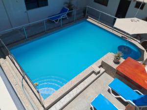 an overhead view of a large swimming pool with blue water at HOTEL PARAACO in Paracas
