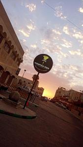 a sign on the side of a street with the sunset at mountain view house in Kerak
