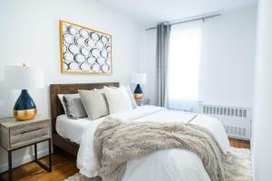 1 dormitorio con 1 cama con sábanas blancas y mesita de noche en 49-4A Prime Midtown newly 2BR WD, en Nueva York