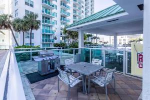 een patio met een tafel en stoelen en een grill bij Beautiful Brickell Loft with Free Parking in Miami