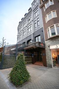 ein Gebäude mit einem großen grünen Busch davor in der Unterkunft Stadshotel Heerlen in Heerlen