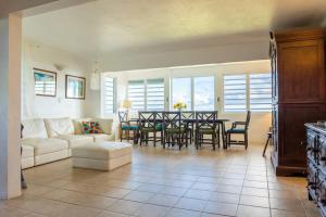 sala de estar con sofá, mesa y sillas en Hill Top Apartment with 360 Degree Balcony View, en Vieques