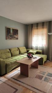 a living room with a couch and a coffee table at Cozy Ivana's Apartment in Skopje