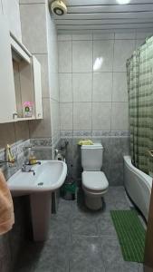 a bathroom with a white toilet and a sink at Cozy Ivana's Apartment in Skopje