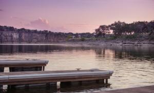 BurnetThunderbird Lodge的码头上有两张长椅的水域