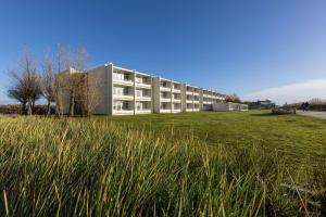 a building on a grassy field in front of a building at IFA Fehmarn Hotel & Ferien-Centrum in Burg auf Fehmarn