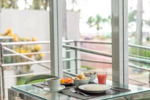 a table with plates of food and drinks on a balcony at Hotel Praia Bonita Jatiúca in Maceió