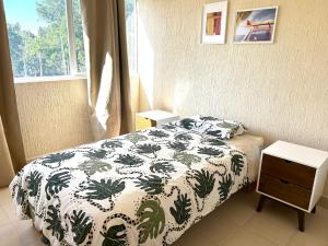 Foro Sol في مدينة ميكسيكو: غرفة نوم بسرير وبطانية خضراء وبيضاء