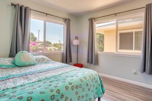 a bedroom with a bed and two windows at Ewa Beach Apartment about 1 Mi to Puʻuloa Beach Park! in Kapolei