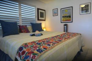 1 dormitorio con 1 cama grande con una manta colorida en Oceanview Apartment with Garden Access, en Vieques