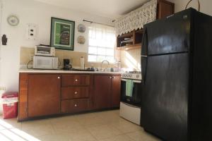 cocina con nevera negra y microondas en Oceanview Apartment with Garden Access, en Vieques
