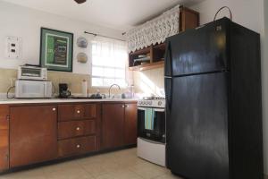 cocina con nevera negra y fogones en Oceanview Apartment with Garden Access, en Vieques