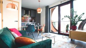 uma sala de estar com um sofá verde e uma mesa em Huis met de krul em Amsterdã