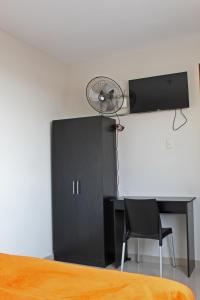 a bedroom with a black cabinet and a desk with a fan at Hotel Sengor in Urbanizacion Buenos Aires +11 photos