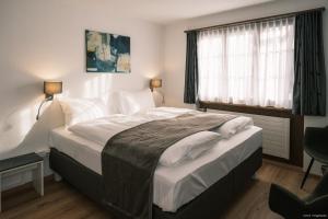 Un dormitorio con una cama grande y una ventana en Gasthof Tenne, en Lenk