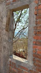 an open window in a brick wall with a tree at Casa Queña, in the heart of Mazunte in Mazunte
