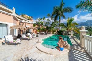 a woman sitting in a pool at a villa at Royal Garden Villas, Luxury Hotel in Adeje