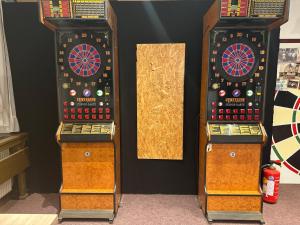 a couple of darts machines sitting against a wall at Gasthof Seelhofer in Prigglitz