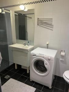 a bathroom with a washing machine and a sink at Feriehus med ti senger på Skaidi in Hammerfest