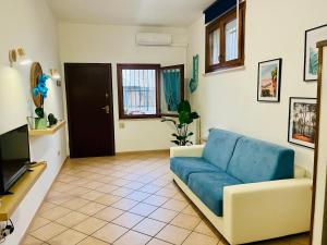 a living room with a blue couch and a tv at Casa Saline in Tarquinia